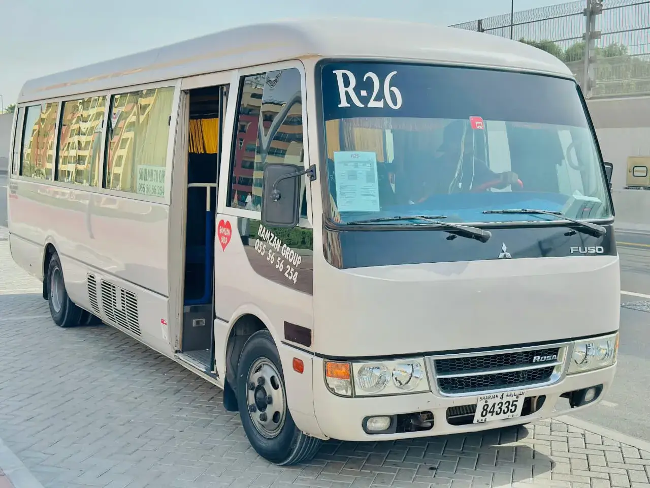 Clean white Coaster van used for staff transport by Ramzan Group